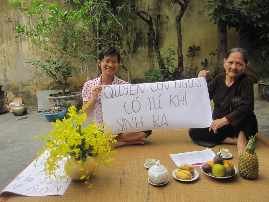 Hai Phong, 9 am, 5 May 2013: former political prisoner Pham Thanh Nghien and her mother in their back yard. The sign reads: "[We have] human rights since we were born." 